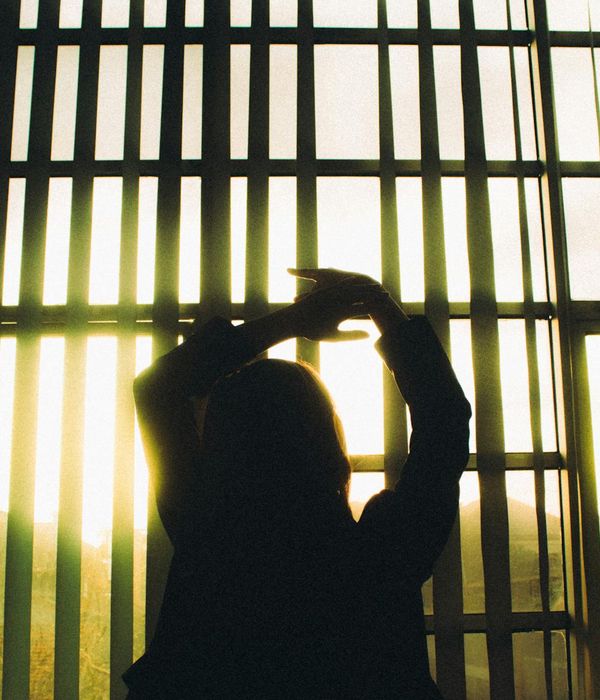 Woman in a graceful yoga pose with warm honey light accents.